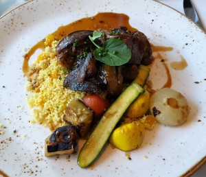“I Am Africa” braised lamb shank with Moroccan couscous, apricot, pine nuts and roasted vegetables
