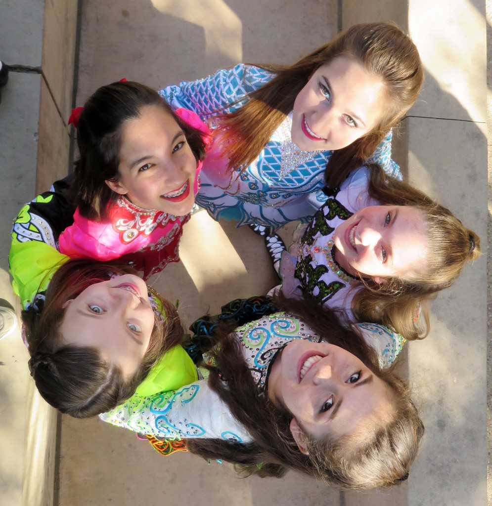 (clockwise, from top right in blue) Gillian Ippoliti, McKenna Walsh, Eva Stanton, Samantha Stoke, and Kaitlin Ryan from Anair Irish Dance School pose for a photo before performing. — Photo by Sara Hall ©