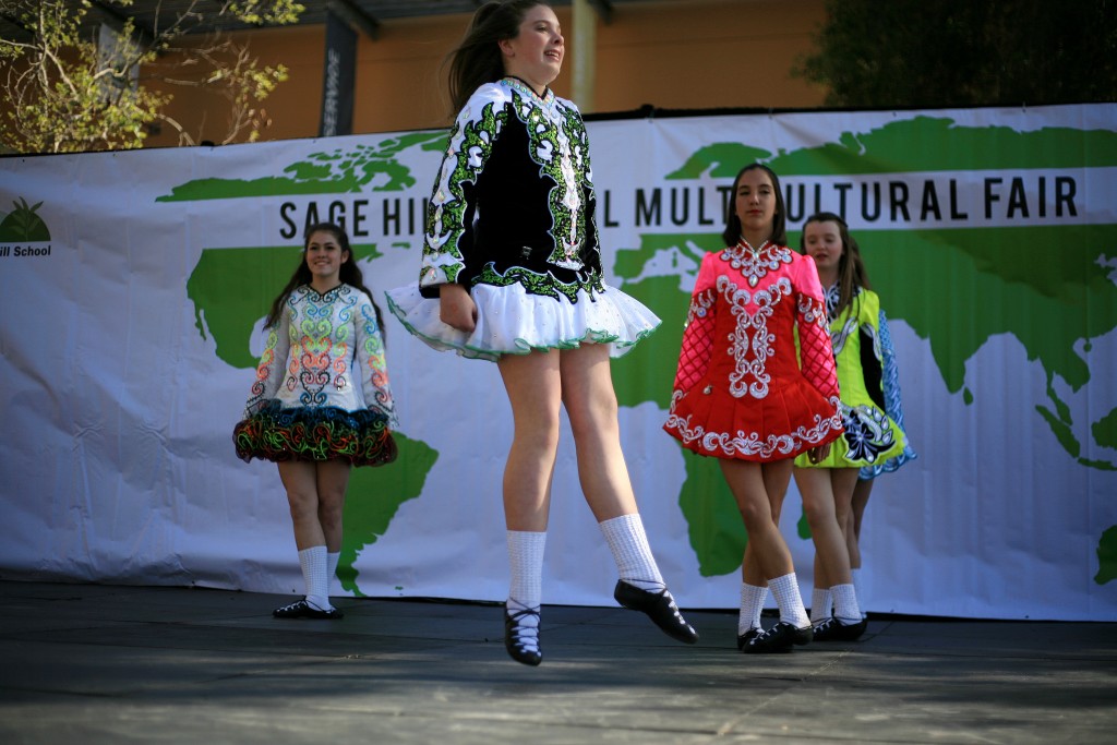 McKenna Walsh (front) leaps in the air while she and Kaitlin Ryan (front right), Samantha Stoke (back right), Eva Stanton (front left) and Gillian Ippoliti (hidden in back) from Anair Irish Dance School perform a traditional Irish dance. — Photo by Sara Hall ©