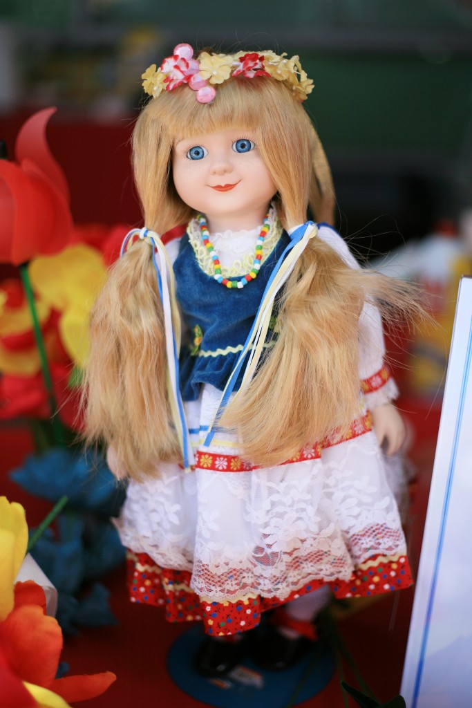 A doll dressed in traditional clothing decorates the Poland booth. — Photo by Sara Hall ©