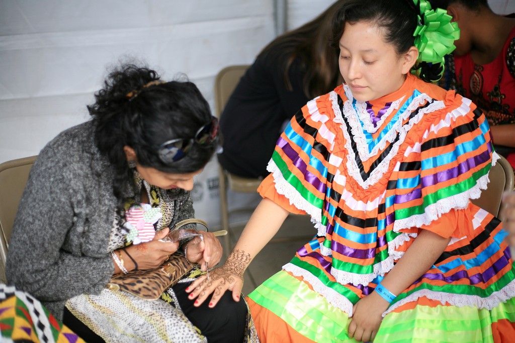 Rana Mohiuddin of Think Outside the Vase draws henna on the hand of Sage sophomore Genesis Gonzalez. — Photo by Sara Hall ©