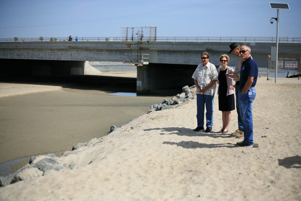 (left to right) Beach Councilman Ed Selich, NB Mayor Diane Dixon, NB Councilman Scott Peotter, and NB City Manager Dave Kiff talk about the unofficial dog beach near the Santa Ana River mouth on Saturday. — Photo by Sara Hall ©