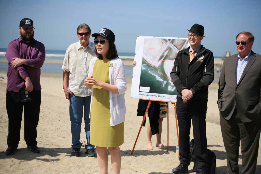 Orange County Board of Supervisors Vice Chair Michelle Steel (front) speaks to (left to right) council candidate and dog beach proponent Mike Glenn, Newport Beach Councilman Ed Selich, Assemblyman Matthew Harper, and NB Councilman Keith Curry, and dog owners, residents, and others Saturday about her proposal about making the property at the Santa Ana River mouth an official off leash area for dogs. — Photo by Sara Hall ©