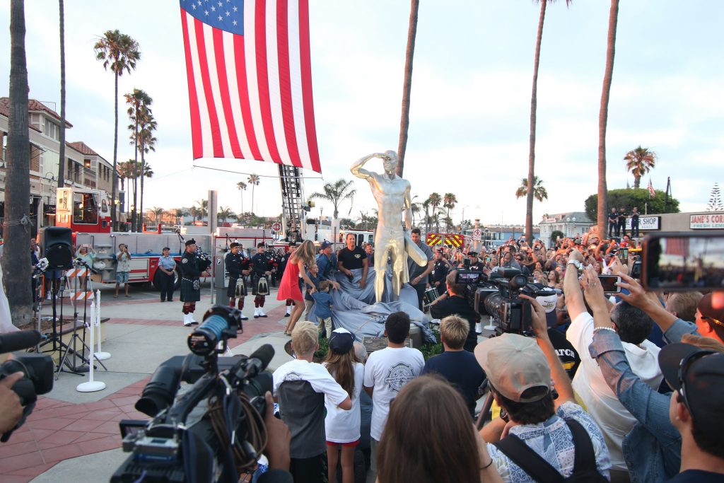 People cheer and take photos as friends and family members of Ben Carlson, the first Newport Beach lifeguard to die in the line of duty, is unveiled Wednesday night. — Photo by Jim Collins ©