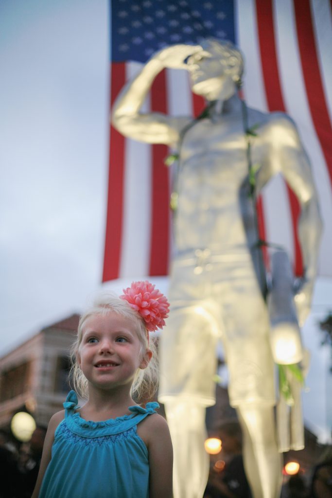 Grace Graham, 5, daughter of longtime Newport Beach lifeguard Chris Graham, poses for photos in front of the statue. — Photo by Sara Hall ©