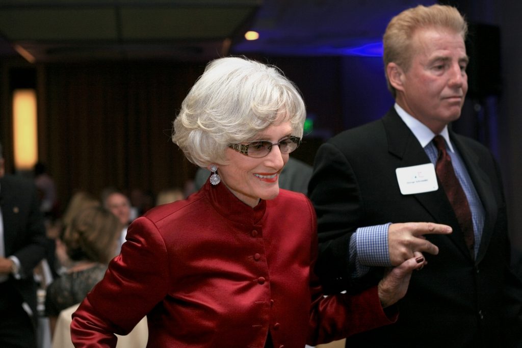 Marian Bergeson is escorted to the stage by George Schroeder to receive the SUNshine Award at Speak Up Newport’s 33rd Mayor’s Dinner in 2014. — Photo by Sara Hall ©