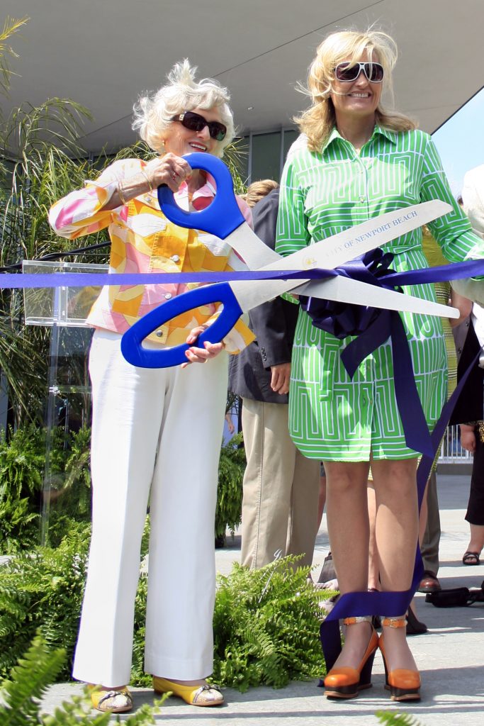 Marian Bergeson and former Newport Beach City Councilwoman Leslie Daigle pose for a photo cutting the ribbon at the grand opening ceremony of the new civic center in 2013. — Photo by Sara Hall ©