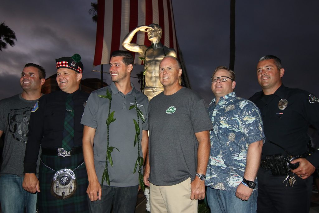 Friends and colleagues of Ben Carlson's pose for a photo with the statue erected in his honor on Wednesday. — Photo by Jim Collins ©