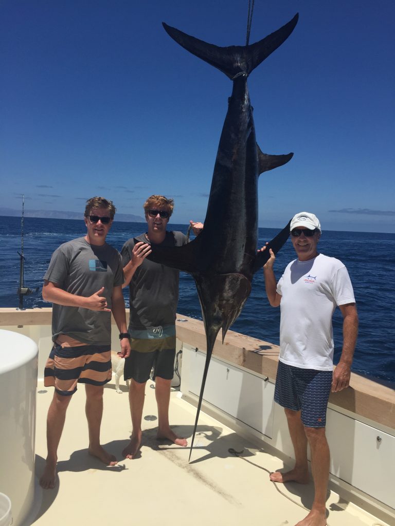 (left to right) Henry, James and Rick Staunton with their 195-pound swordfish. — Courtesy Bluewater Grill ©