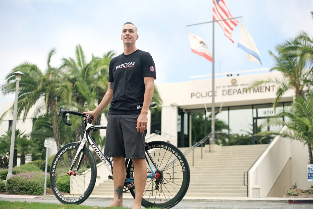 Newport Beach Police Department Detective Jason Prince poses with his bike in front of the NBPD station. Prince will be participating in the upcoming 1,500-mile Freedom Ride, which aims to raise awareness for human trafficking. — Photo by Sara Hall ©