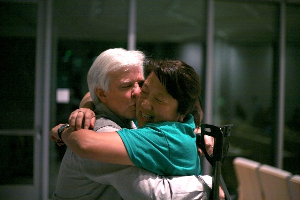 Banning Ranch Conservancy executive director Steve Ray hugs and kisses his wife, Shan, in celebration after the Coastal Commission voted to deny the proposed development. — Photo by Sara Hall ©