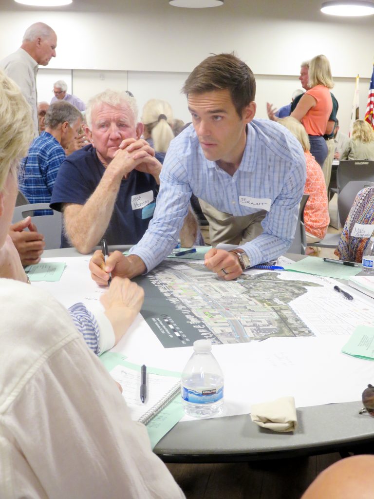 Brant Birkeland, a PlaceWorks associate, discusses Mariners’ Mile Revitalization Master Plan with members of the public during the meeting Monday. — Photo by Sara Hall ©