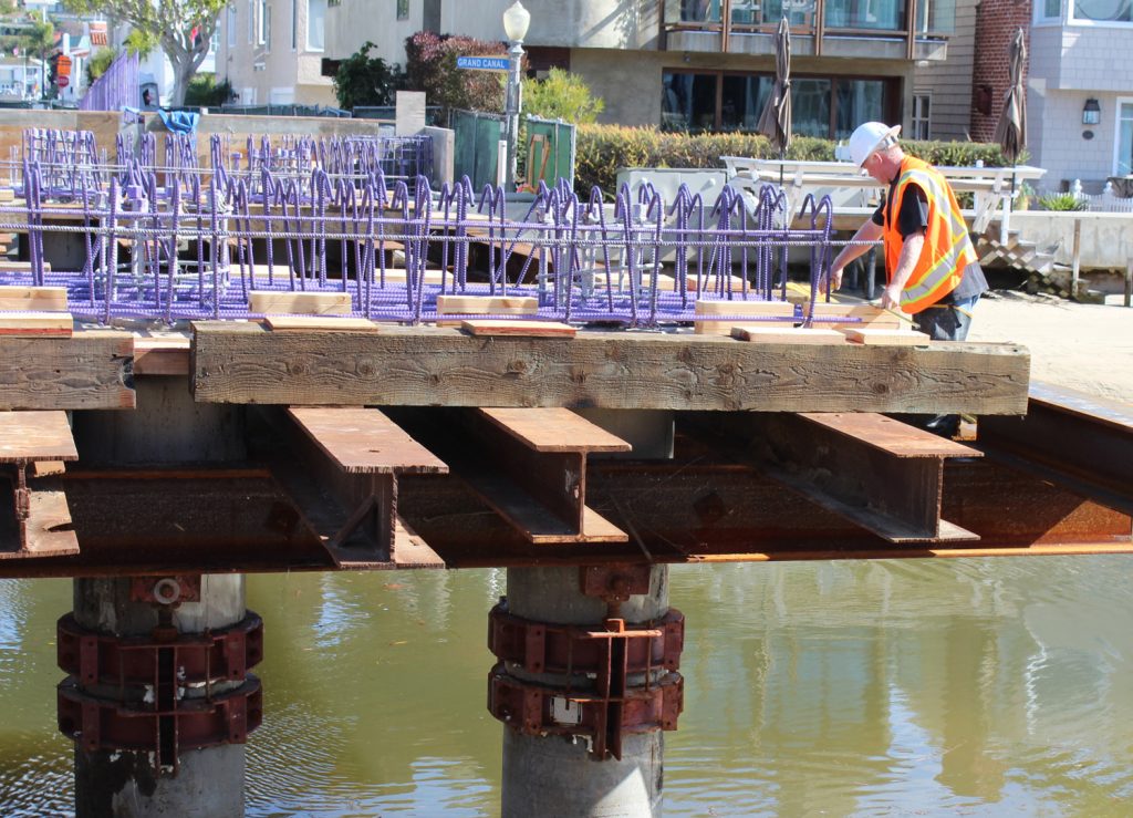 A worker measures reinforcement bars atop falsework on Park Avenue Bridge on Balboa Island — Photo by Victoria Kertz ©