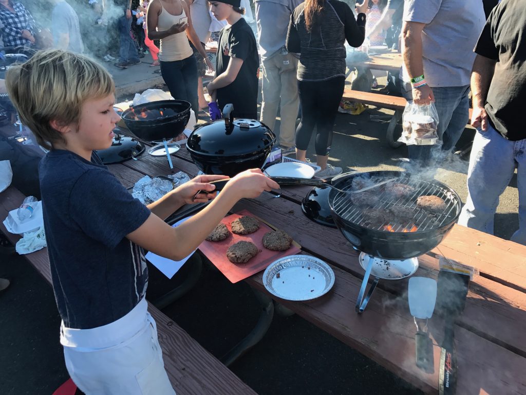 Young grill master Peter Kertz flips a burger in the kid’s competition