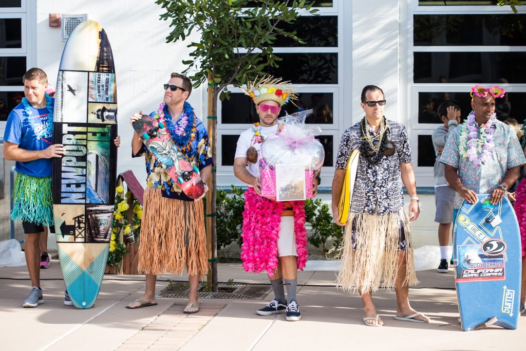 The Hula for Moola fundraising event kicked off March 10 at the Newport Elementary School morning flag deck with a group of Newport El dads dressed up as hula dancers and performing in front of about 500 students. — Photo courtesy Dena Baron , co-chair of Newport El School Foundation ©