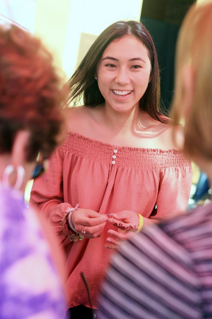 Sage Hill senior Abby McGuire, 17, talks with fair attendees about her group’s service learning project, COAST, an organization they started to be ocean advocates and study and protect marine life. — Photo by Sara Hall ©