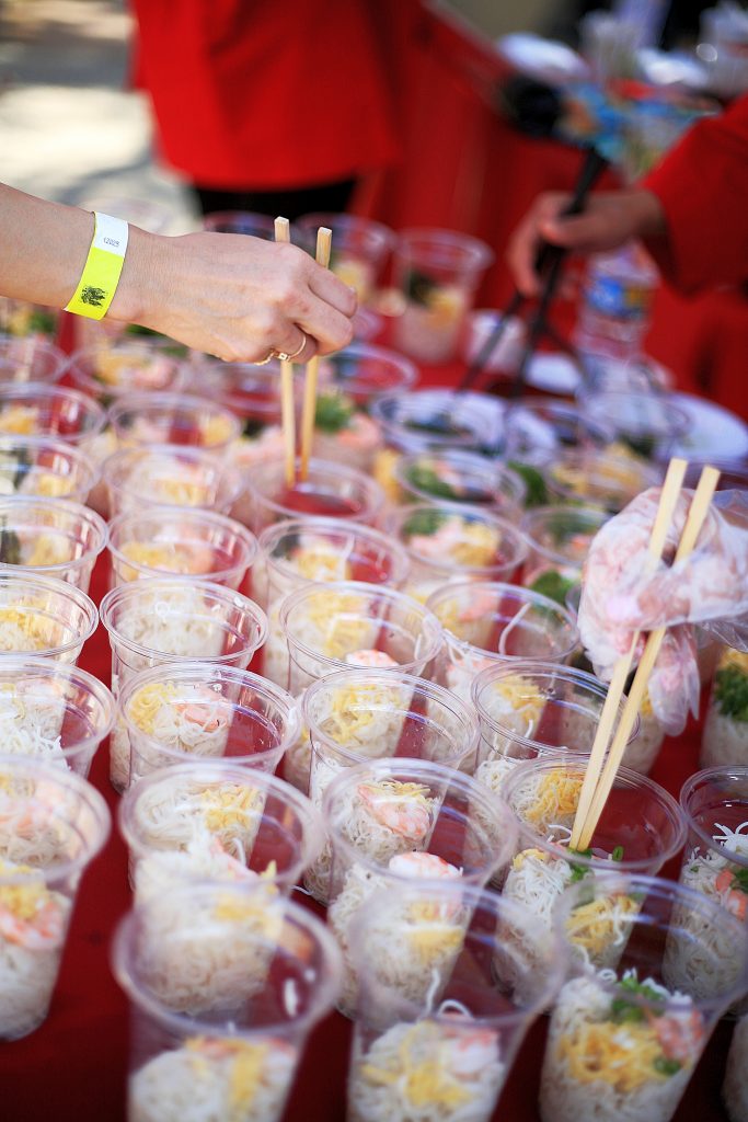 Sage parents Junko Hara, Emi Nishinaka and Reiko Stauss fill cups with chilled somen noodles for the Japan food booth.  — Photo by Sara Hall ©