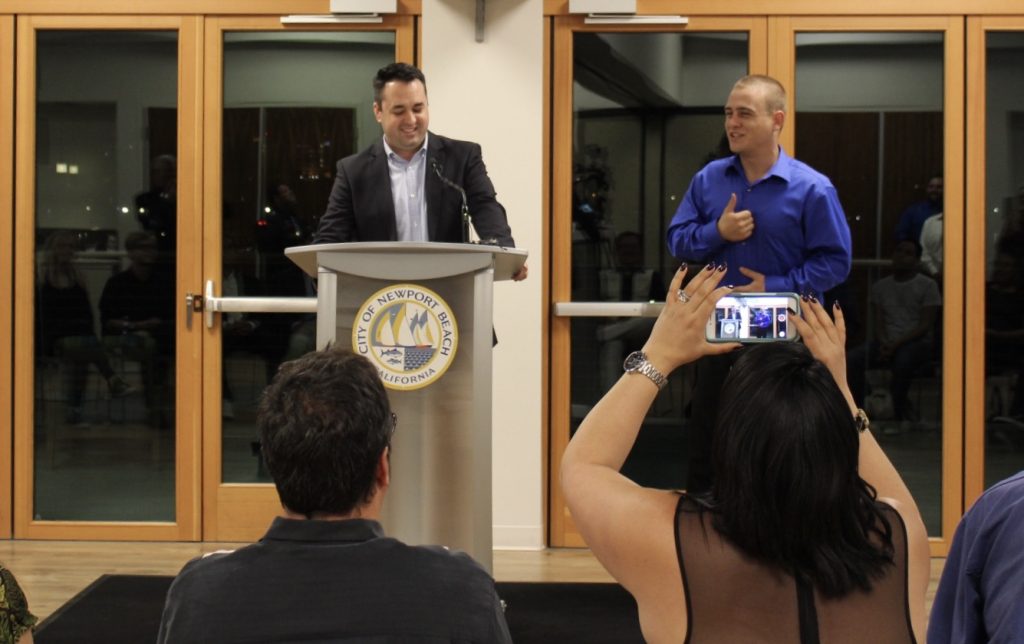 An interpreter signs and smiles as he translates Newport Beach Mayor Kevin Muldoon's speech during the deaf-friendly event on Friday. — Photo by Victoria Kertz ©