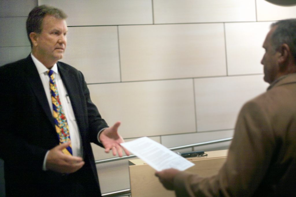 Councilman Scott Peotter takes the official notice of recall paperwork from resident Paul Blank at Tuesday’s meeting.  — Photo by Sara Hall ©