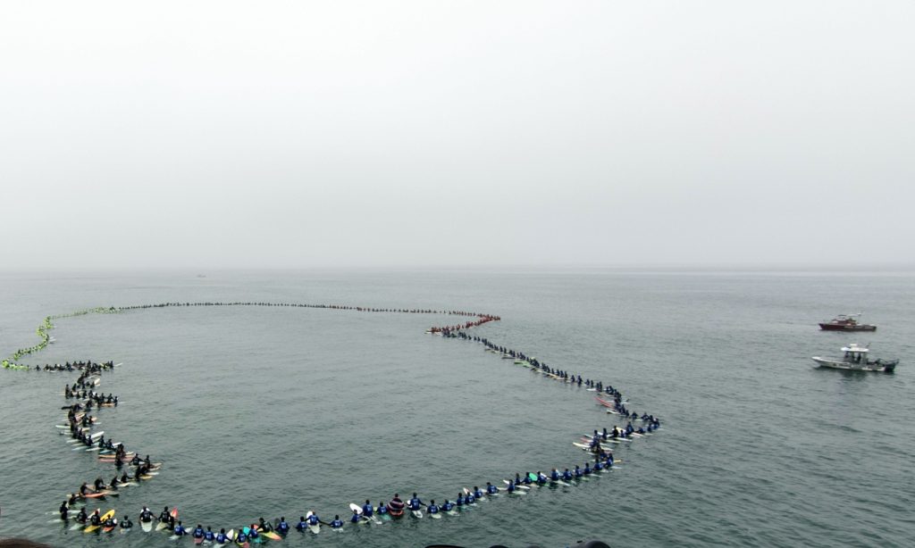 A total of 511 surfers hold hands and form a circle in Huntington Beach on Tuesday, breaking a Guinness World Record for largest surfing paddle out. — Photo by Jim Collins ©