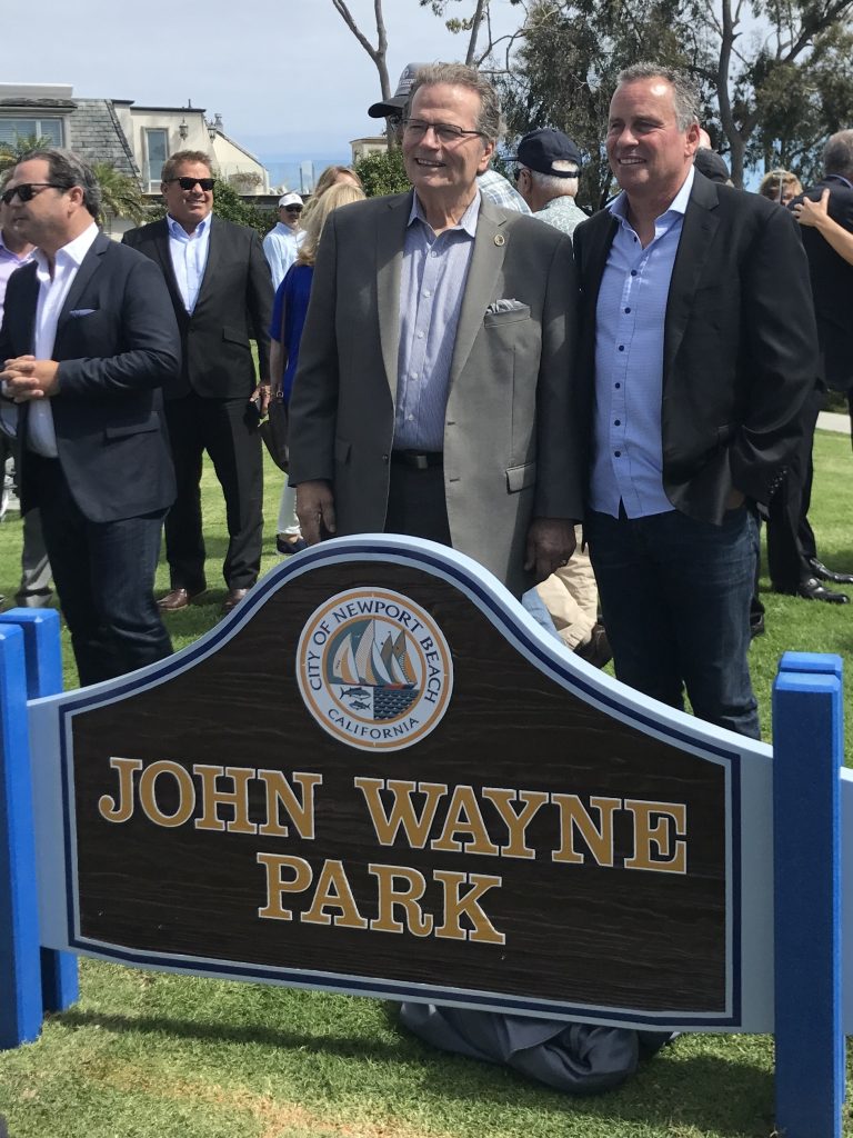 Patrick (left) and Ethan Wayne, sons of late actor John Wayne, pose for photos by the new sign for John Wayne Park. — Photo by Victoria Kertz ©