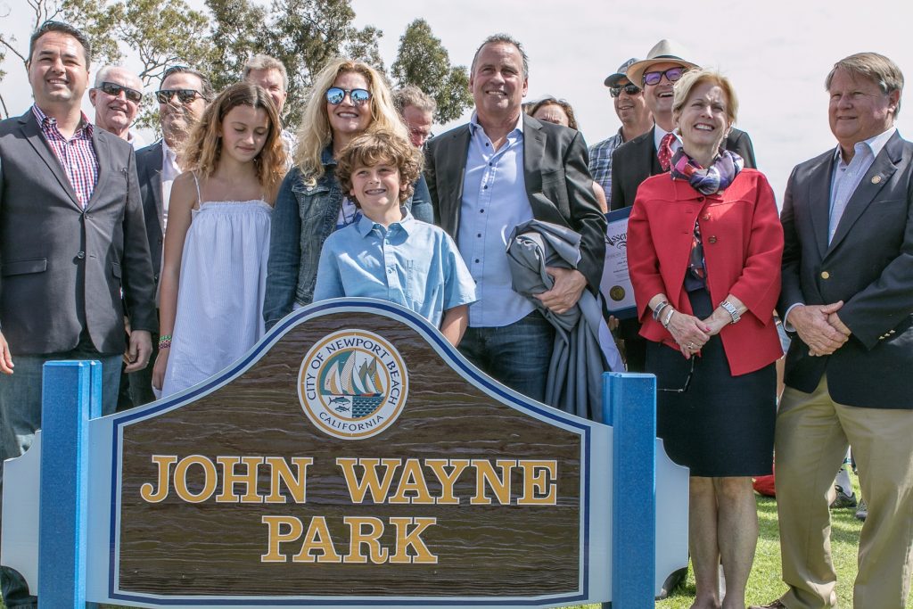 Family members of Newport Beach's famous former resident, John Wayne, pose for photos with city and regional officials by the sign for the park recently named after the actor. — Photo by VJim Collins ©